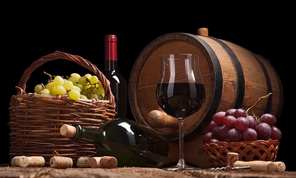 Натюрморт из бочки, винограда, бутылок и бокала с вином