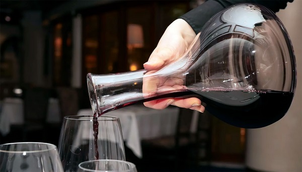 Вино наливают из декантера в бокал